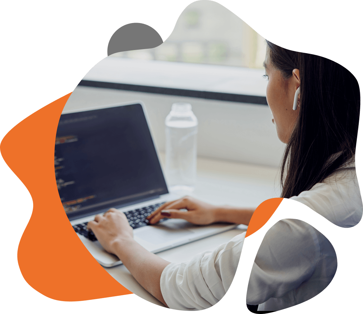 Mulher trabalhando em um laptop, analisando códigos de TI na tela, representando a aplicação de soluções tecnológicas.